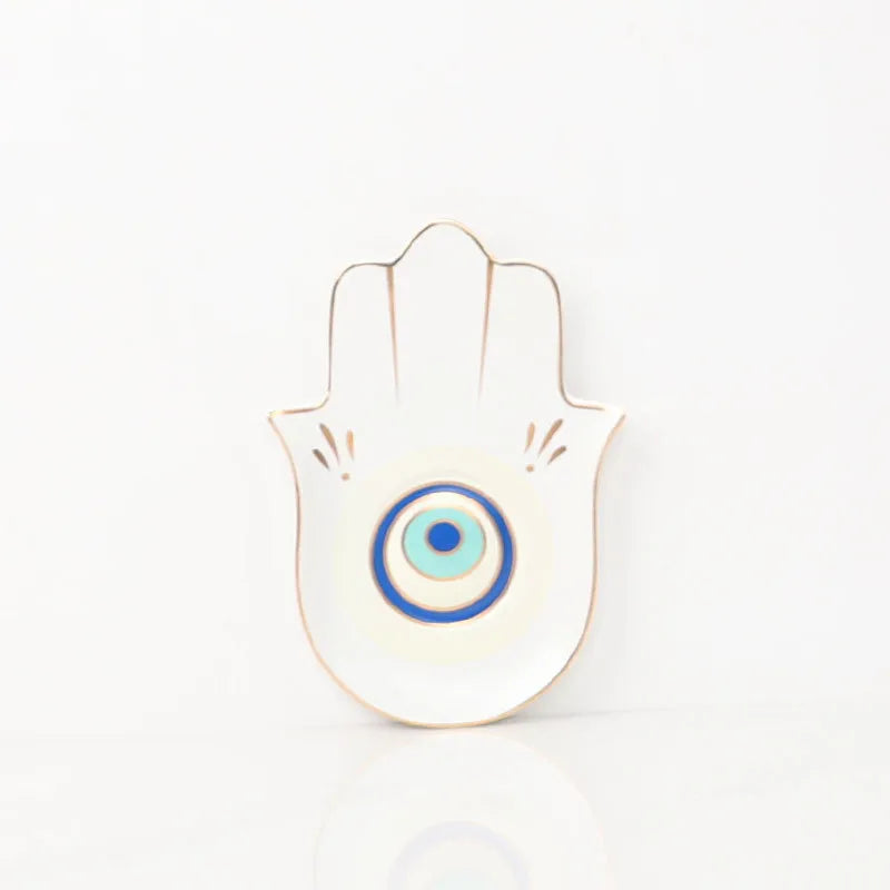 Decorative Hamsa hand with a blue eye design on a white background